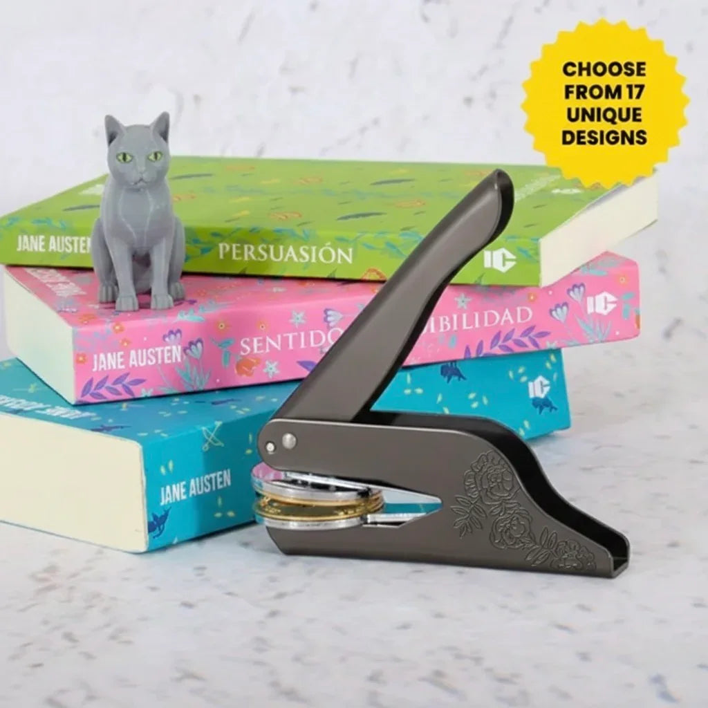 Custom library book embosser with a cat theme, displayed next to books and a cat figurine.